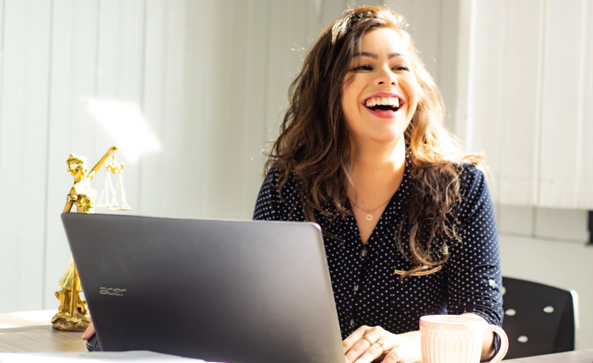 woman-working-at-her-laptop-and-laughing