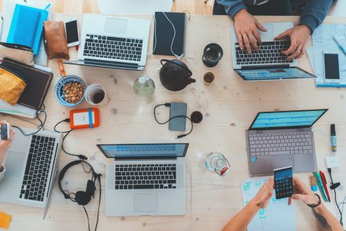 many-laptops-phones-and-hard-drives-set-up-at-a-desk-viewed-from-overhead