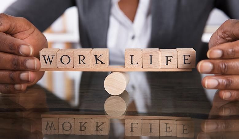 the-words-work-and-life-on-wooden-blocks-balancing-on-a-wooden-cylinder