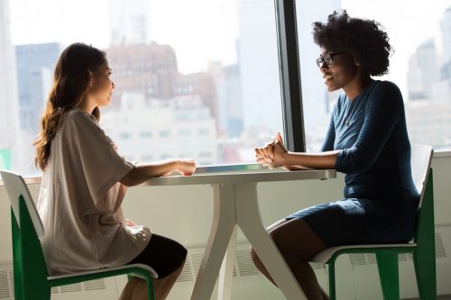 two-women-sitting-at-a-table-during-a-meeting-or-job-interview