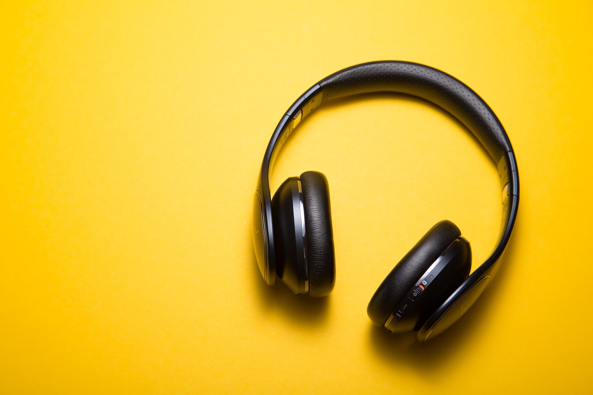 black-wireless-headphones-on-a-yellow-background