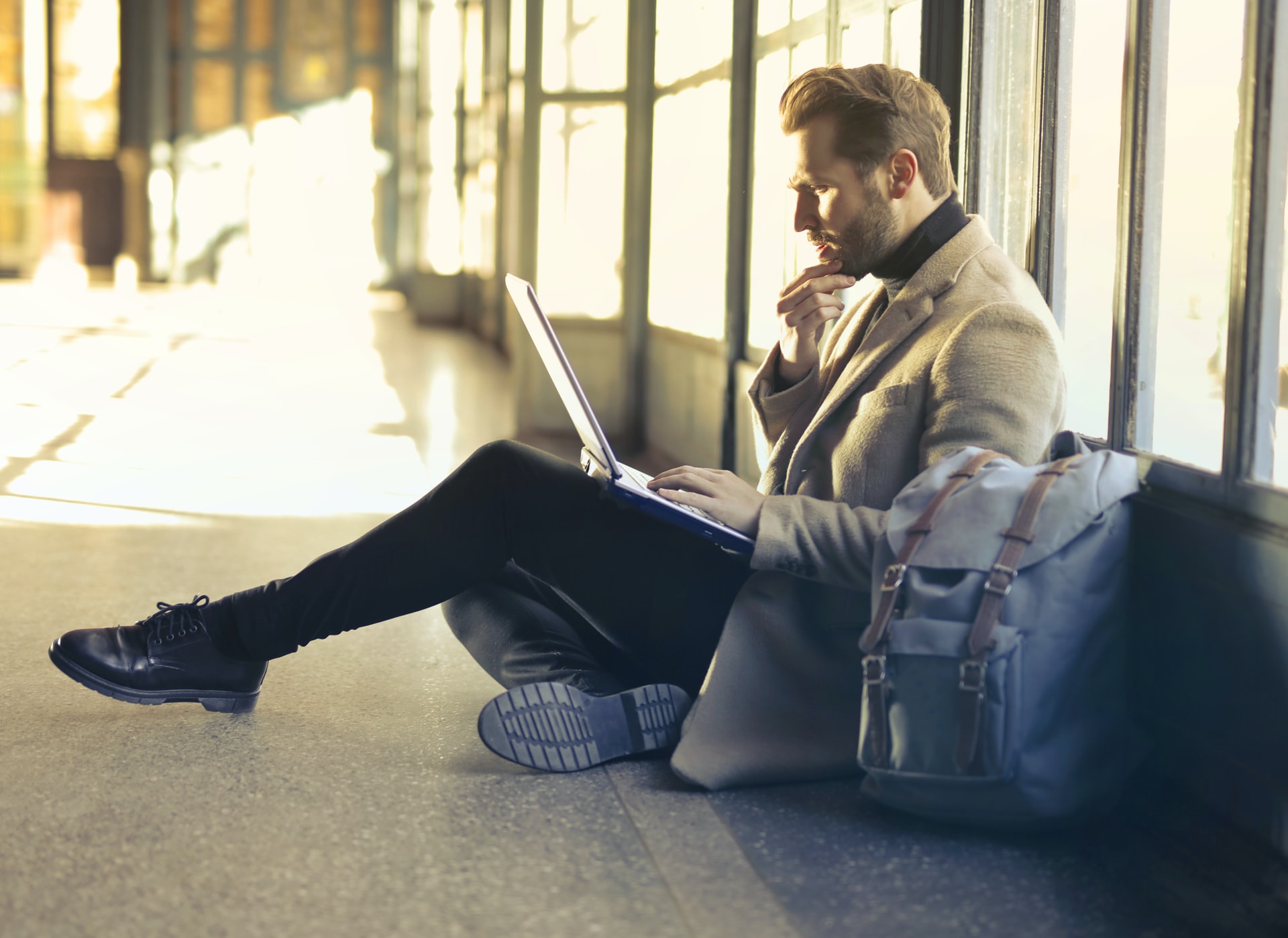 man-sitting-on-the-floor-working-on-a-laptop