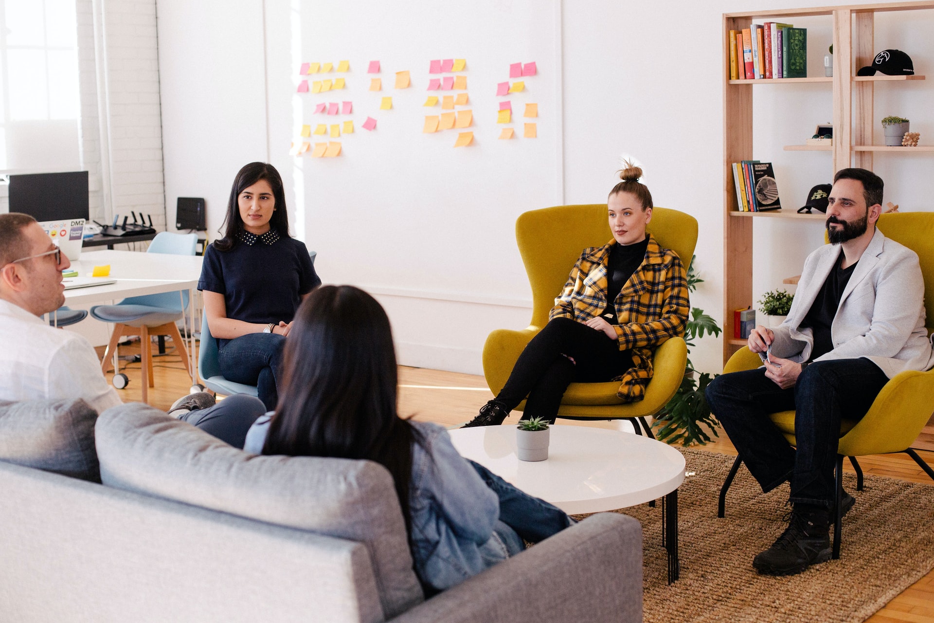 an-image-of-five-people-sitting-in-chairs-brainstorming-ideas