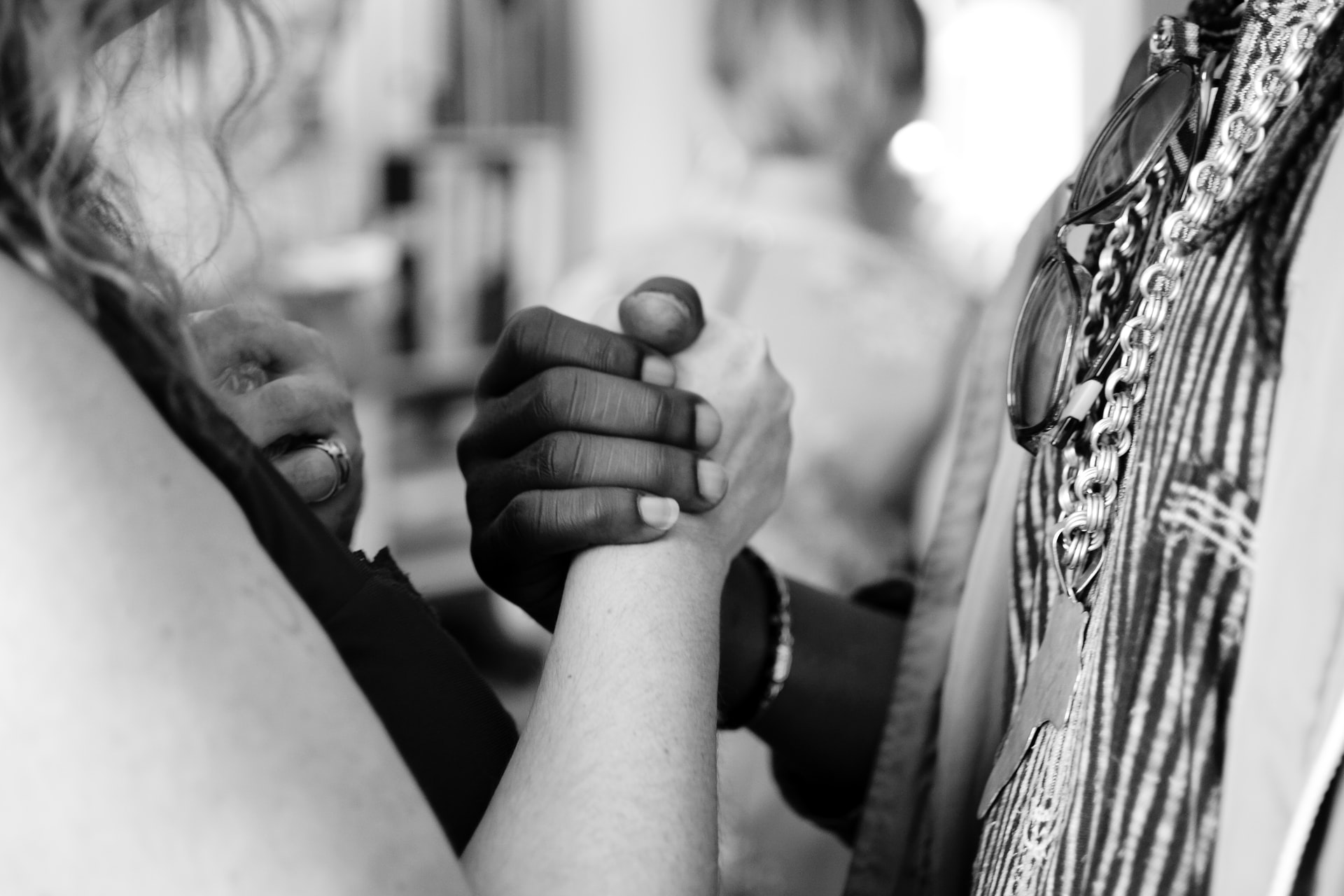 black-and-white-photograph-of-two-people-holding-hands-in-solidarity