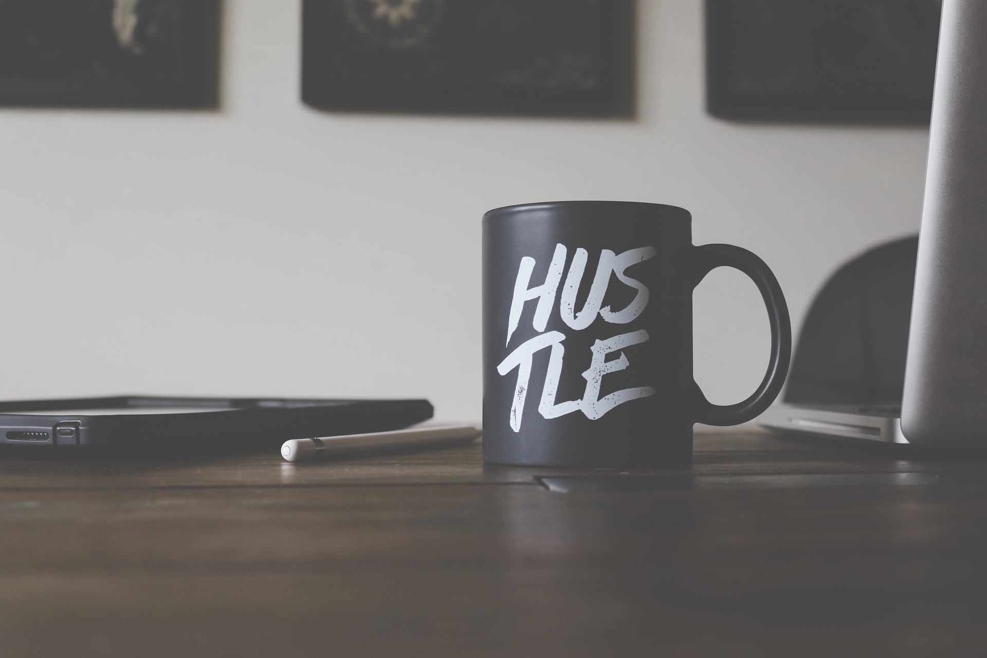 black-and-white-shot-of-a-mug-with-hustle-printed-on-the-side
