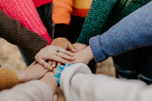 image-of-eight-people-putting-hands-into-the-centre-in-a-show-of-teamwork