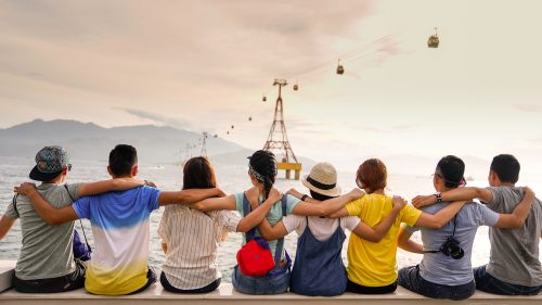 image-of-eight-people-sitting-on-a-dock-with-their-arms-on-eachothers-shoulders