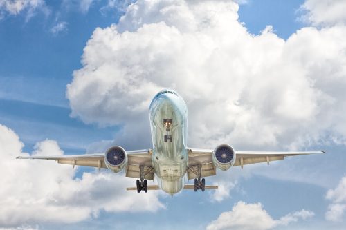 undershot-of-an-airplane-flying-through-cloudy-but-blue-skies