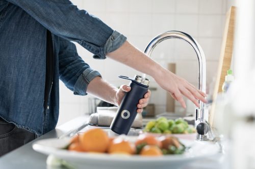 person-filling-up-a-metal-water-bottle-from-a-tap