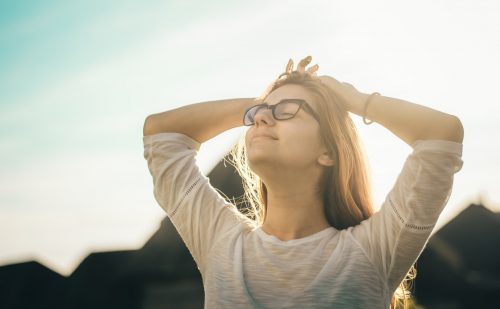 woman-with-her-hands-on-her-head-relaxed-and-looking-free-outside