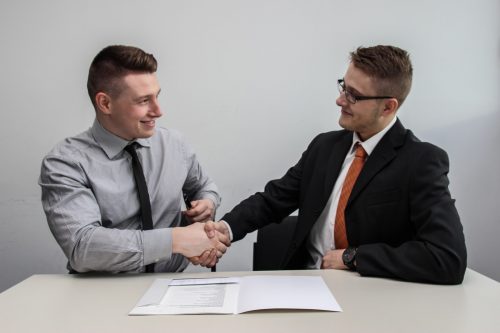 two-businessmen-shaking-hands-and-smiling