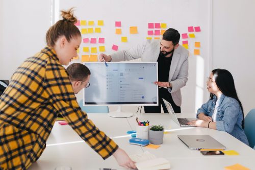 workers-around-a-computer-screen-learning-in-a-bright-office