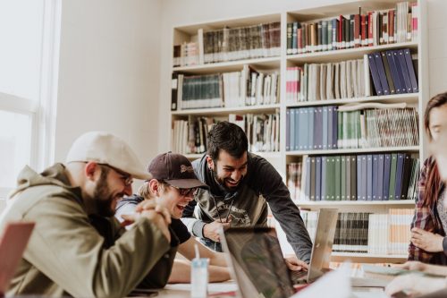 employees-gathered-round-a-computer-laughing