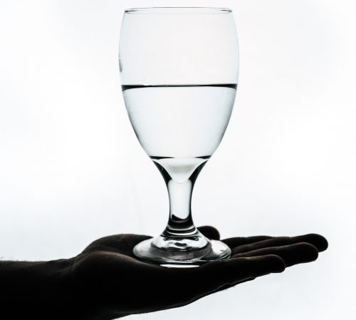image-of-a-glass-half-full-of-water-balancing-on-a-hand