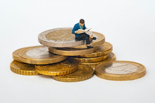 image-of-coins-with-a-small-figuring-sitting-on-top