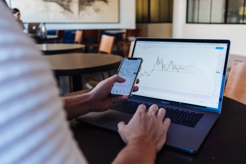 over-shoulder-shot-of-a-person-working-on-a-laptop-looking-at-graphs