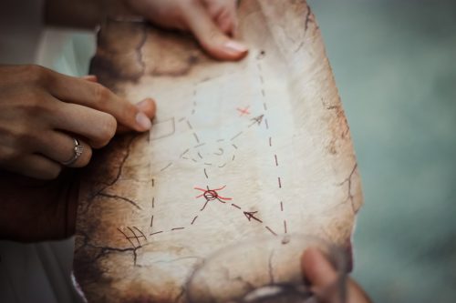 close-up-of-a-treasure-map-and-people-trying-to-figure-it-out