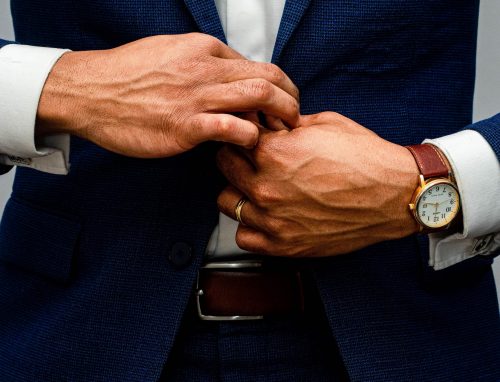 close-up-of-a-man-in-a-blue-suit-doing-up-a-button