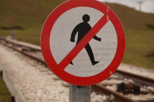 close-up-of-a-road-sign-with-a-figure-walking-and-a-red-line-through-it