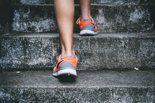 shot-of-a-persons-feet-walking-up-stone-steps-with-shoes-on