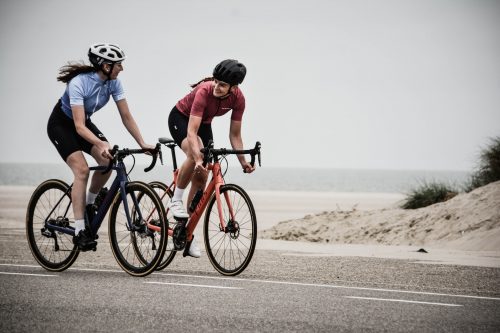 two-people-riding-bicycles-on-a-road-and-smiling