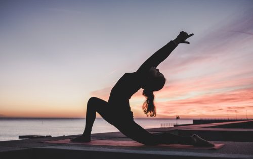woman-doing-a-yoga-pose-outside-bending-backwards-with-her-hands-in-the-air