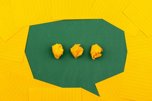 shot-of-yellow-paper-laid-out-in-the-pattern-of-a-speech-bubble