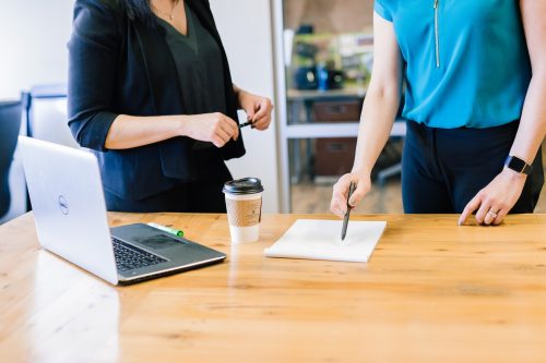 two-women-standing-at-a-table-negotiating-a-new-deal