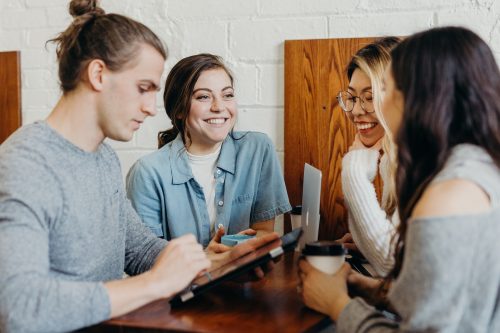 photograph-of-four-happy-young-people-working-over-coffee