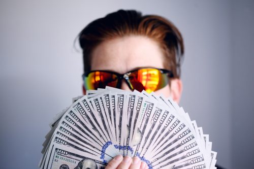 image-of-a-man-holding-up-many-money-bills-in-front-of-him