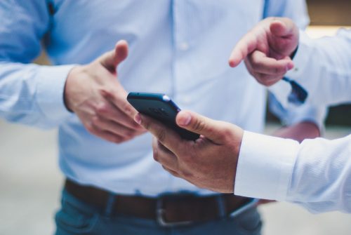 image-of-two-people-discussing-something-on-a-phone-with-one-person-pointing-at-the-phone