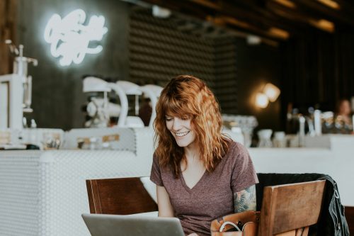 woman-working-alone-at-a-computer-smiling-and-laughing