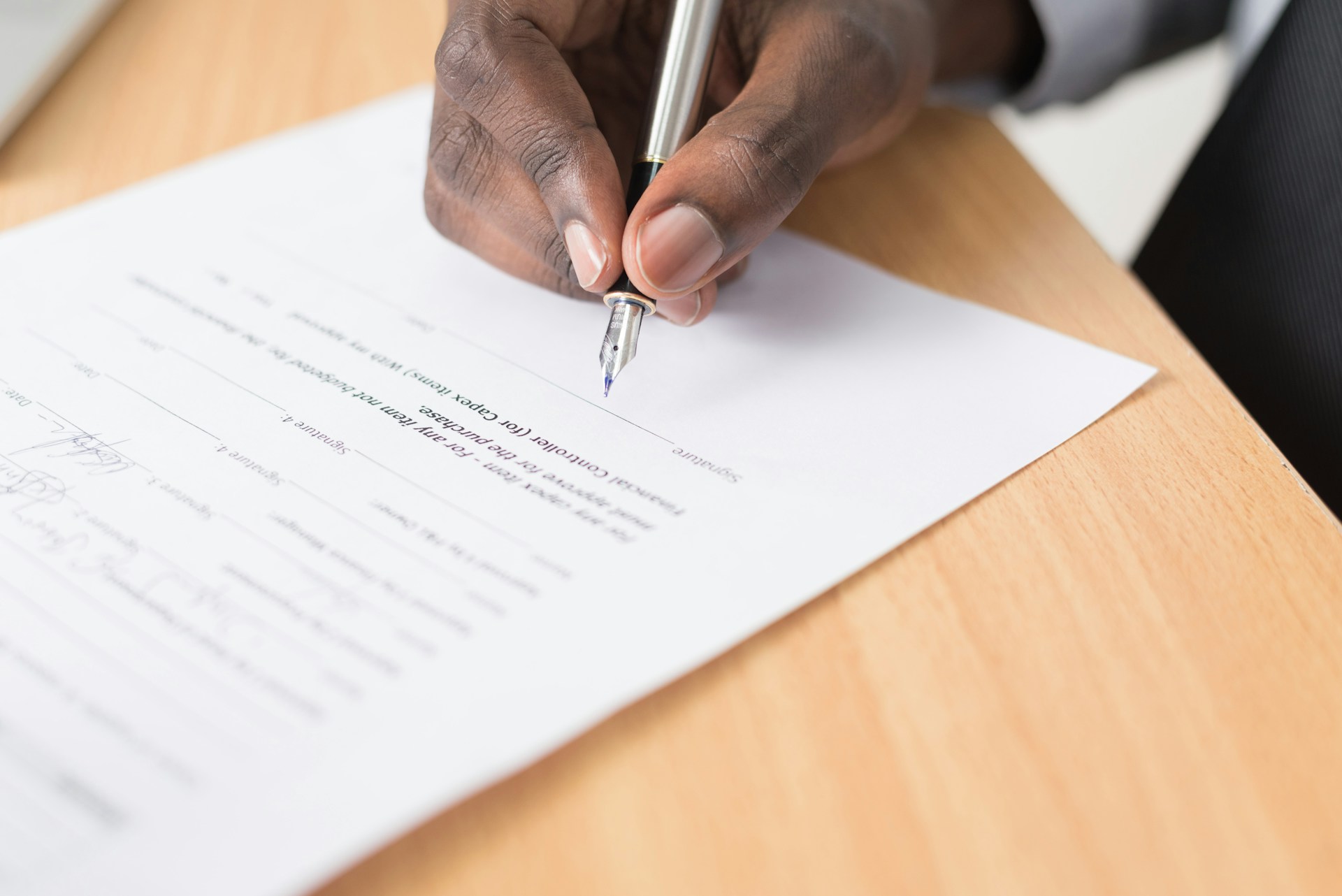 man-signing-a-contract-with-a-fountain-pen-close-up