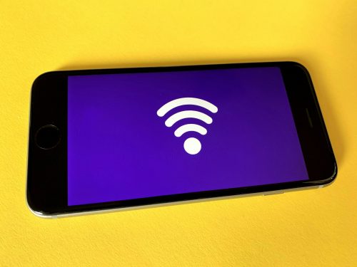 smartphone-on-yellow-background-showing-a-wifi-symbol-on-a-purple-background-on-the-screen
